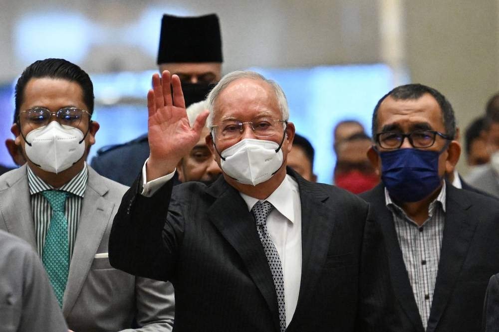 Datuk Seri Najib Razak waves as he arrives at the federal court in Putrajaya, August 23, 2022. — AFP pic 