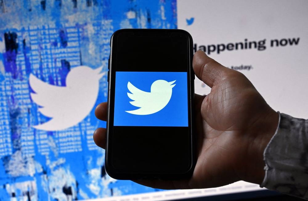 In this file photo illustration taken on April 26, 2022, a phone screen displays the Twitter logo on a Twitter page background in Washington, DC. — AFP pic