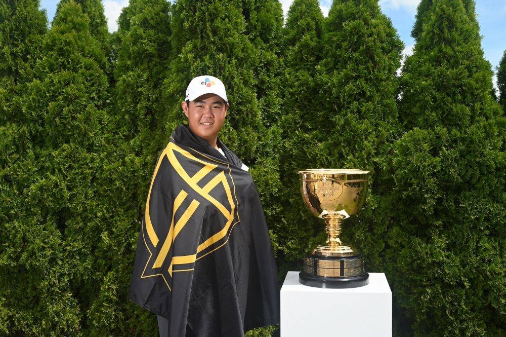 Joohyung Kim with the International Team flag and Presidents Cup. — Picture via PGA Tour