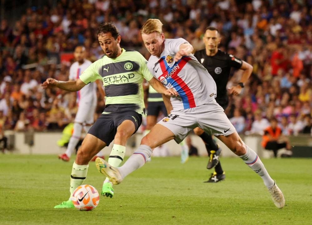  FC Barcelona's Frenkie de Jong in action with Manchester City's Bernardo Silva (right) at Camp Nou, Barcelona August 24, 2022. — Reuters pic
