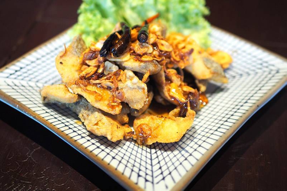 Nibble on 'pa tod nam mak kham' or fried fish fillets drizzled with a tamarind sauce and garnished with chillies and deep fried garlic chips