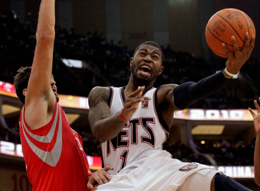 Terrence Williams (right) of the New Jersey Nets goes to the basket against Brad Miller of the Houston Rockets during the NBA China Games series at the Guangzhou International Sports Arena in Guangzhou October 16, 2010. — Reuters pic