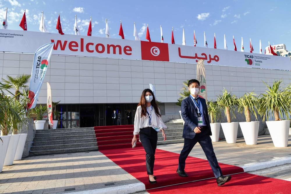 Attendees walk outside the Congress Palace, hosting the eighth Tokyo International Conference on African Development, in Tunisia’s capital Tunis on August 27, 2022. — AFP pic