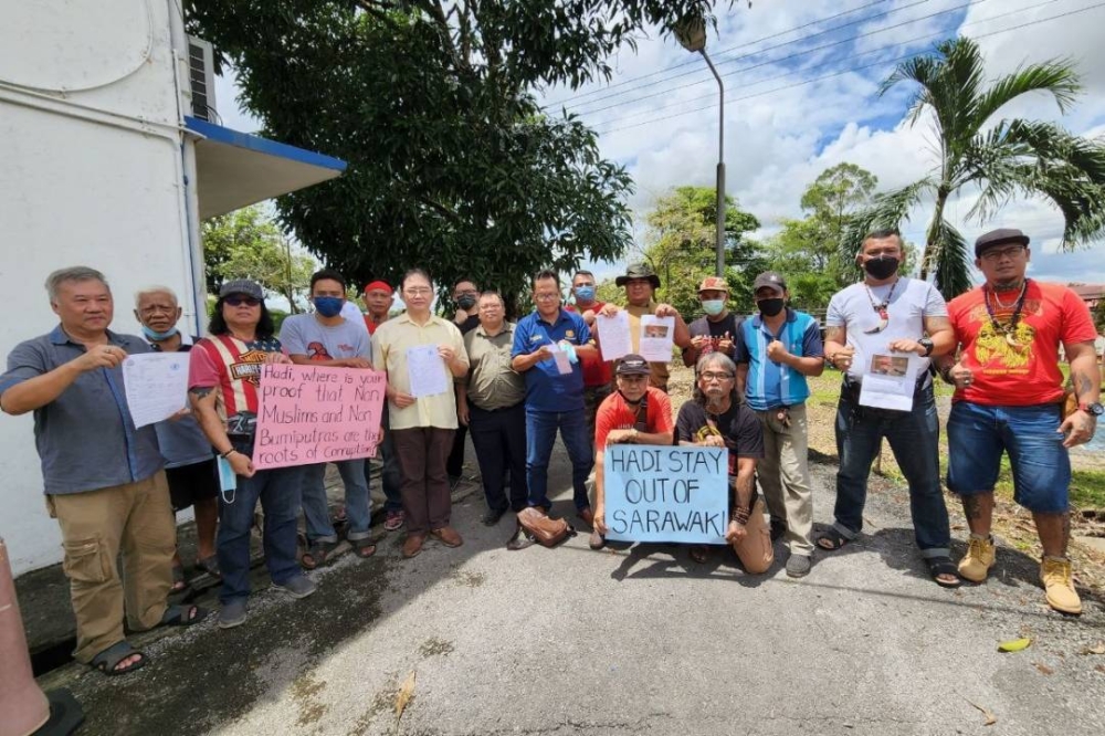 Ng (6th left) and members of the NGOs who lodged the police report. — Borneo Post pic