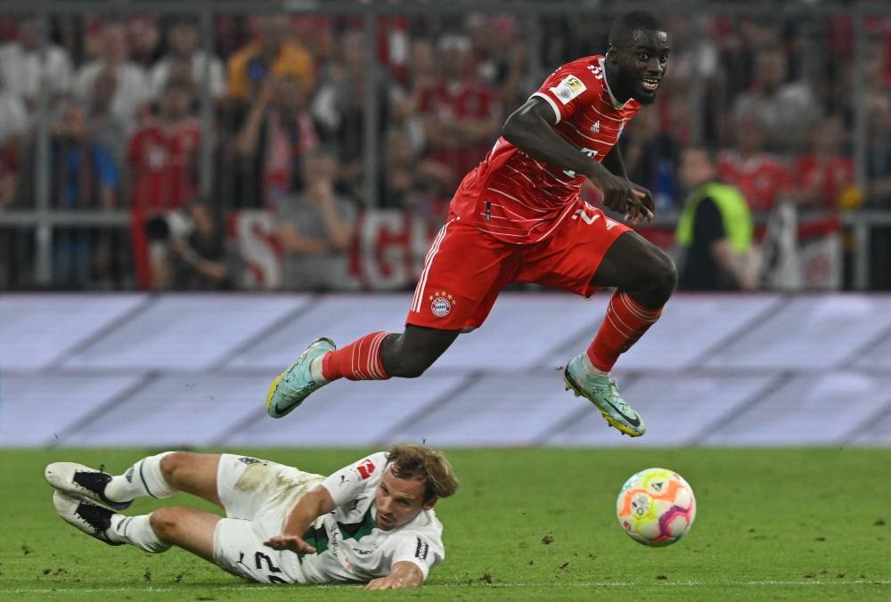 Bayern Munich's French defender Dayot Upamecano (right) jumps over Moenchengladbach's German defender Tony Jantschke during the German first division Bundesliga match between Bayern Munich and Borussia Moenchengladbach in Munich, southern Germany on August 27, 2022. — AFP pic