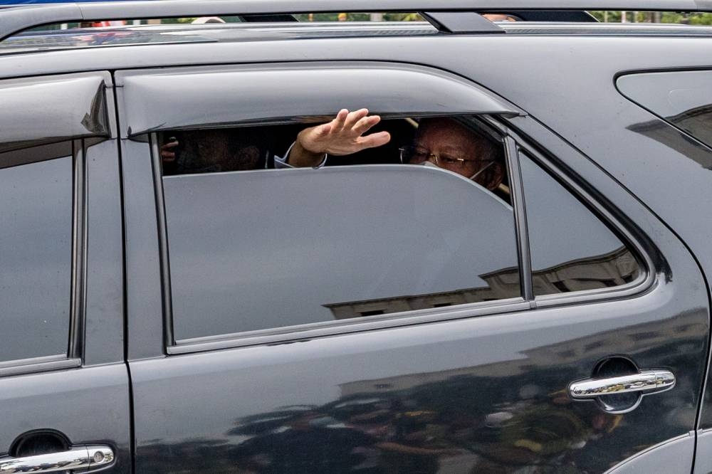 Jailed former Prime Minister Datuk Seri Najib Razak waving to his supporters as he leaves the Kuala Lumpur Court Complex, August 25, 2022. — Picture by Firdaus Latif