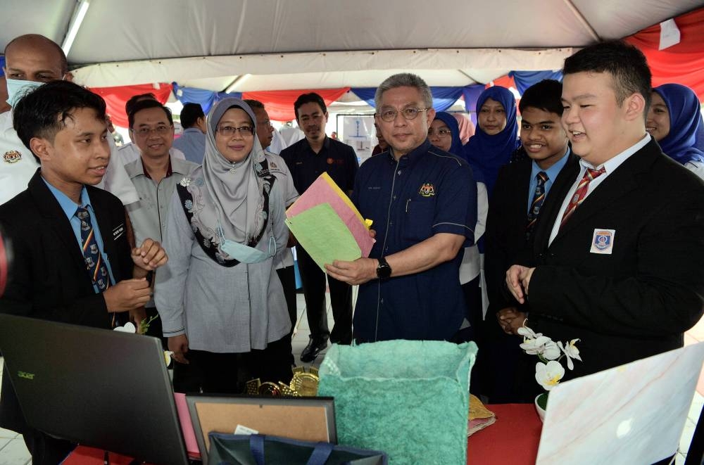 Science, Technology and Innovation Minister Datuk Seri Dr Adham Baba looks at paper made from banana trunks which is part of a project from SMK Pengerang Utama after opening the Science, Technology, Engineering and Mathematics (STEM) Carnival in conjunction with the 2022 Keluarga Malaysia National Science Week in Kota Tinggi August 28, 2022. — Bernama pic