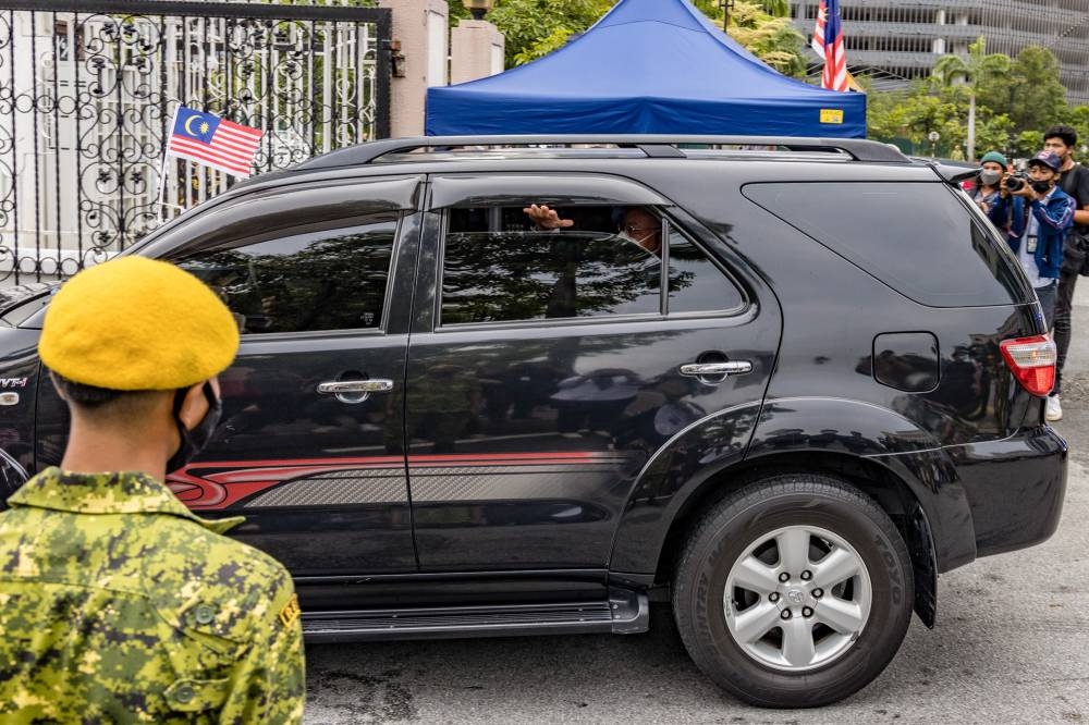 Jailed former prime minister Datuk Seri Najib Razak waves to his supporters as he leaves the Kuala Lumpur Court Complex, in Kuala Lumpur August 25, 2022. — Picture by Firdaus Latif