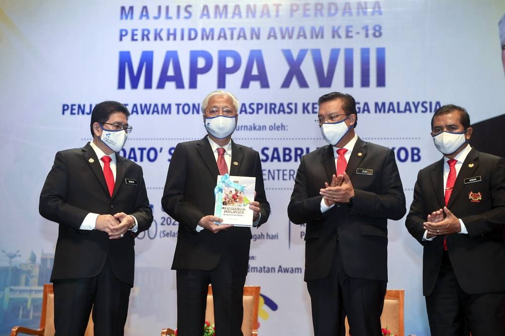 Prime Minister Datuk Seri Ismail Sabri Yaakob launches a book at the Putrajaya International Convention Centre in Putrajaya, August 30, 2022. With him are Chief Secretary to the Government Tan Sri Mohd Zuki Ali (2nd, right) and Public Services director-general, Datuk Seri Mohd Shafiq Abdullah (left). — Bernama pic 