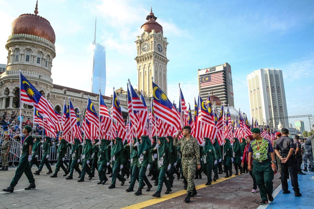 Performers carry Malaysian flags during the rehearsal for the 65th Merdeka Day celebrations at Dataran Merdeka in Kuala Lumpur August 28, 2022. ― Picture by Yusof Mat Isa