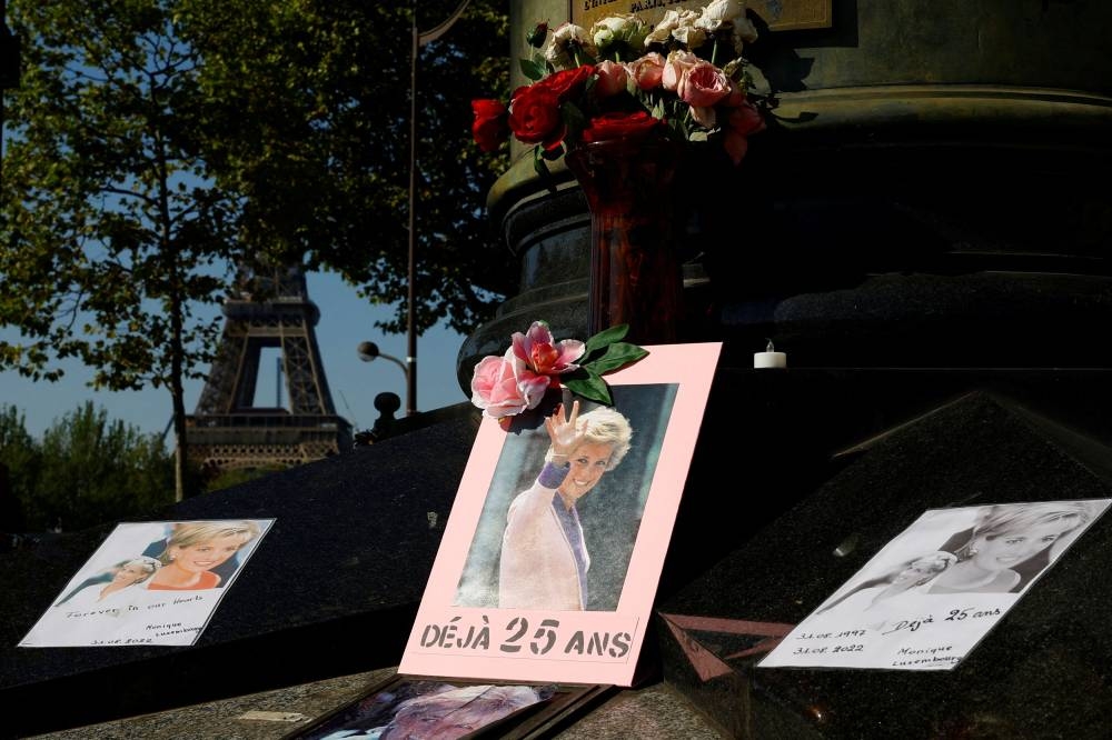 Pictures and flowers are left in memory of the late Princess Diana around the Liberty Flame monument above the tunnel of the Alma bridge where Diana Princess of Wales died in a car accident on August 31, 1997, in Paris, France, August 31, 2022. — Reuters pic