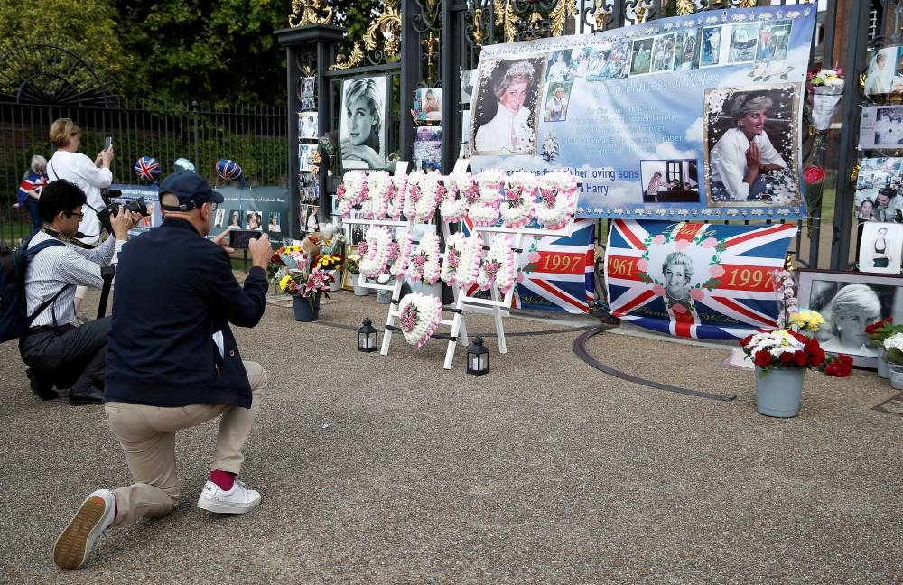 Admirers and a member of the media take photographs of tributes placed outside Kensington Palace on the 25th anniversary of the death of Princess Diana, in London, Britain, August 31, 2022. — Reuters pic
