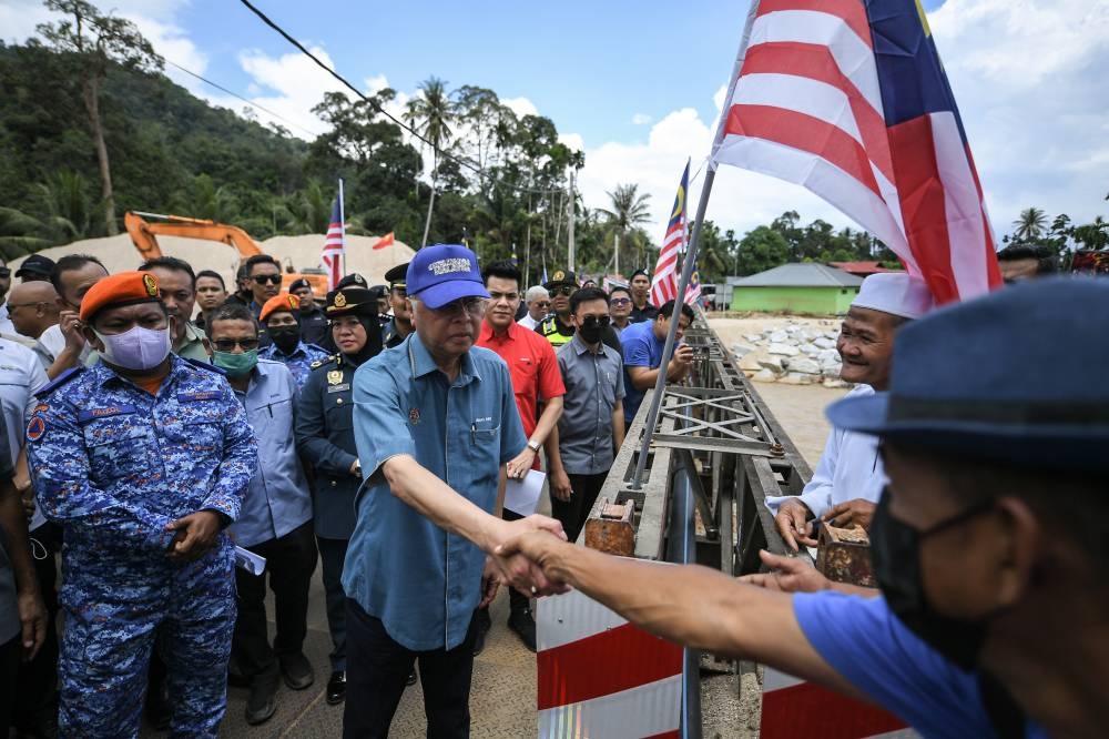 Prime Minister Datuk Seri Ismail Sabri Yaakob greeted residents when inspecting the location of the flood debris and the Bailey bridge in Kampung Iboi, Mukim Kupang, Baling September 1, 2022. — Bernama pic