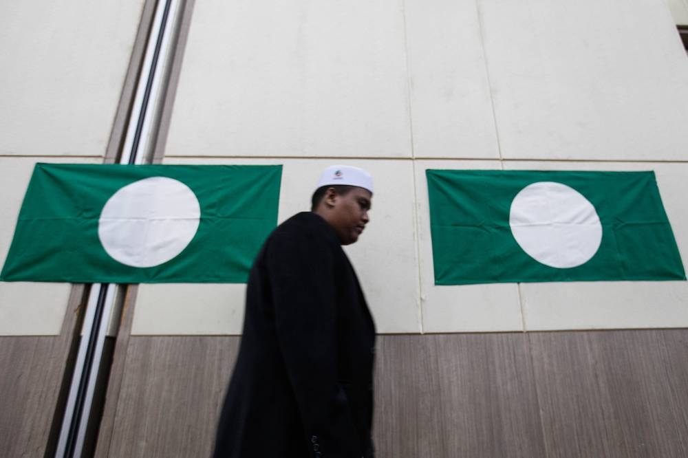 A man walks past PAS flags at the Youth Conference during the party's 68th annual congress at the Raia Hotel and Convention Centre, Alor Setar September 2, 2022. — Picture by Sayuti Zainudin 