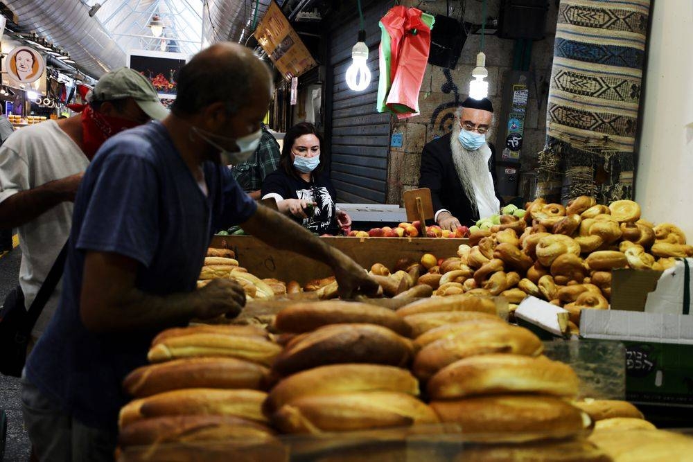 File photo of customers wearing protective face masks shop at a food market as Israel is set to tighten its second nationwide coronavirus disease lockdown amid a rise in infections, in Jerusalem September 24, 2020. — Reuters pic