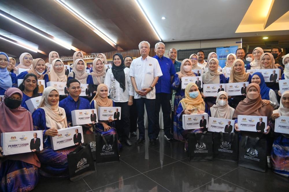 Prime Minister Datuk Seri Ismail Sabri Yaakob posing for a group photo together with students during the launching of Peranti Siswa Keluarga Malaysia initiative at Dewan Agung Tuanku Canselor, UiTM Shah Alam, September 3, 2022. — Picture by Shafwan Zaidon