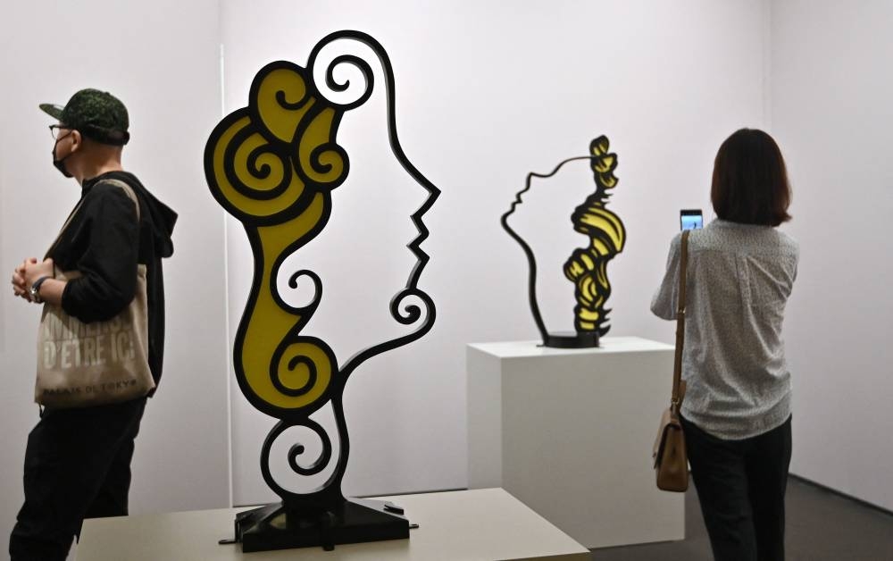 Visitors look at artworks 