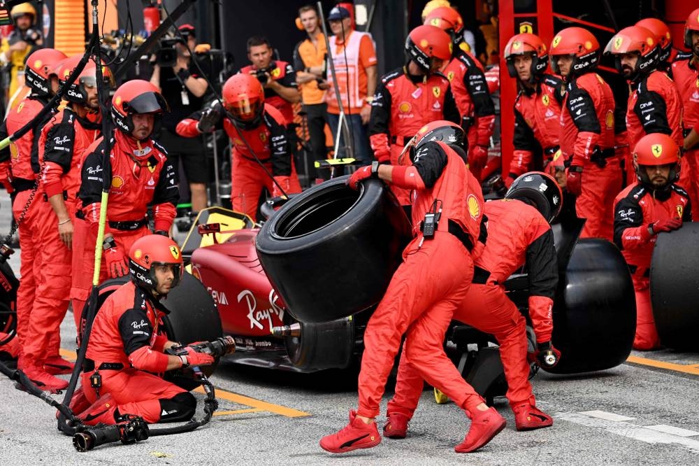 A mechanic carries a tyre for Ferrari's Spanish driver Carlos Sainz Jr in the pits of the Zandvoort circuit during the Dutch Formula One Grand Prix on September 4, 2022. — AFP pic