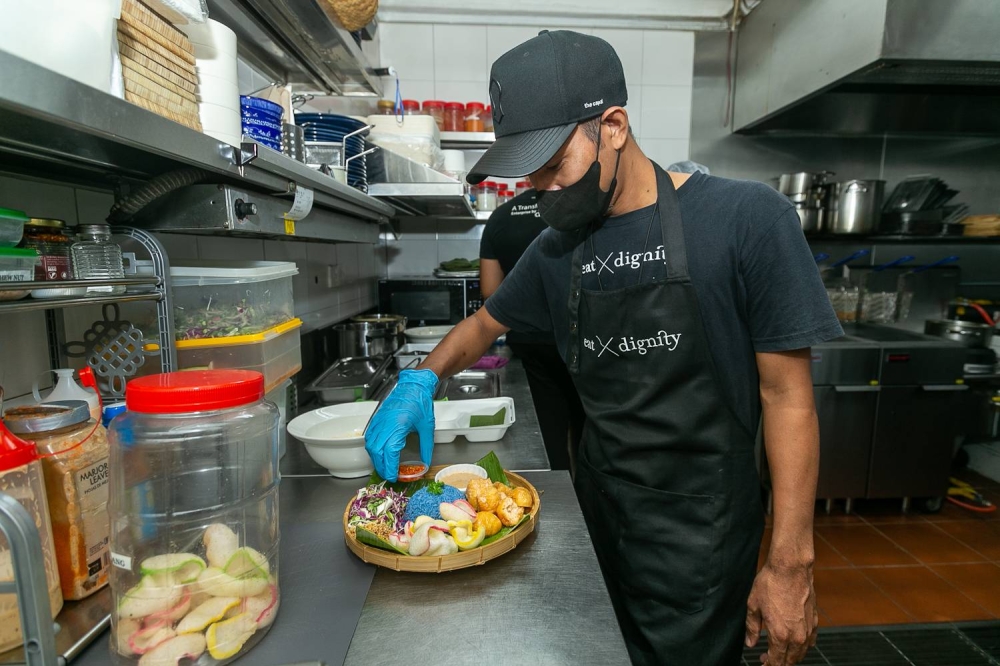 Mohammad Izauni or ‘Chef John’ in action, adding the final touches to his signature ‘Nasi Kerabu’. — Picture by Raymond Manuel