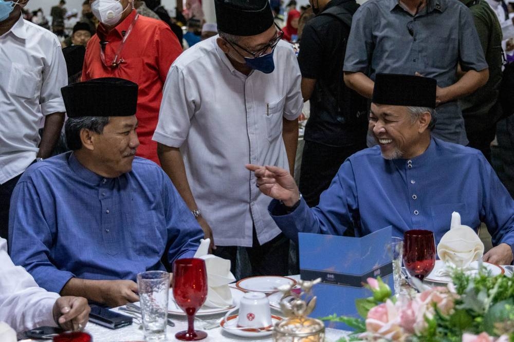 Datuk Seri Mohamad Hasan (seated, left) and Umno president Datuk Seri Ahmad Zahid Hamidi converse during an Umno buka puasa event at the World Trade Centre in Kuala Lumpur on April 14, 2022. — Picture by Firdaus Latif
