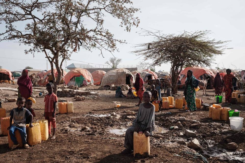 In this file photo taken on February 13, 2022 People wait for water with containers at a camp, one of the 500 camps for internally displaced persons (IDPs) in town, in Baidoa, Somalia. — AFP pic