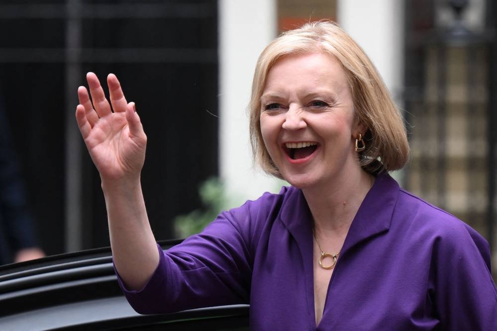 New Conservative Party leader and incoming prime minister Liz Truss smiles and waves as she arrives at Conservative Party Headquarters in central London September 5, 2022. ― AFP pic