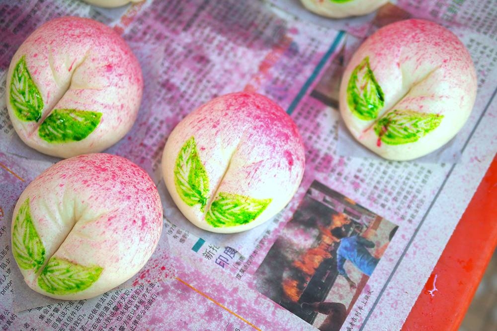 Various types of steamed buns are available including these adorable peach buns.