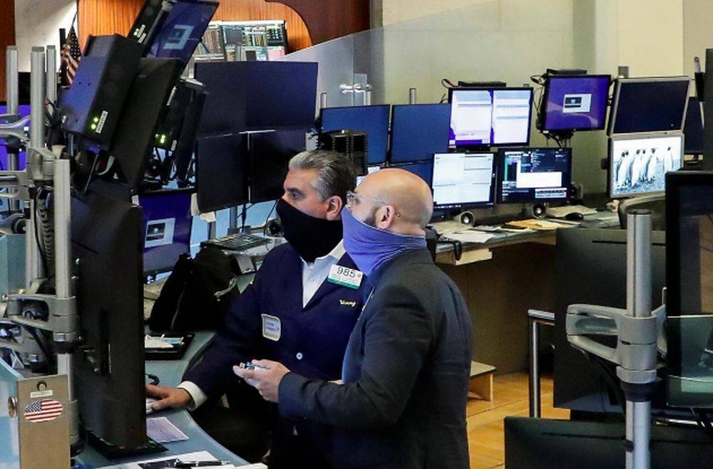 Traders wearing masks work, on the first day of in person trading since the closure during the outbreak of the coronavirus disease (Covid-19) on the floor at the New York Stock Exchange (NYSE) in New York May 26, 2020. — Reuters pic