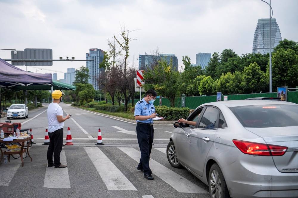 A police officer inspects a car outside the blocked section of Jinjiang Avenue, following a lockdown to curb the coronavirus disease outbreak in Chengdu, Sichuan province, China September 1, 2022. ― cnsphoto via Reuters