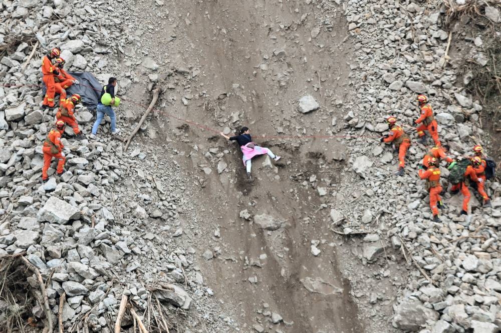 Rescue workers evacuate quake-affected residents at the site of a landslide near Moxi town, following a 6.8-magnitude earthquake in Luding county, Ganzi Tibetan Autonomous Prefecture, Sichuan province, China September 6, 2022. ― China Daily via Reuters