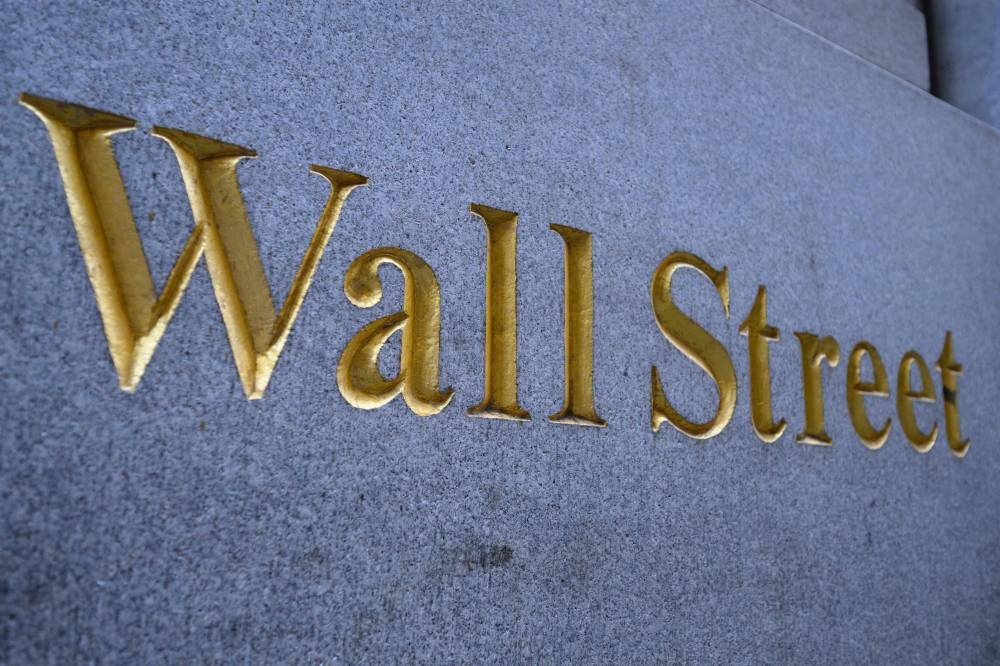 A sign reading 'Wall Street' is seen on a building near the New York Stock Exchange (NYSE) on Wall Street on July 12, 2022 in New York City. — AFP pic