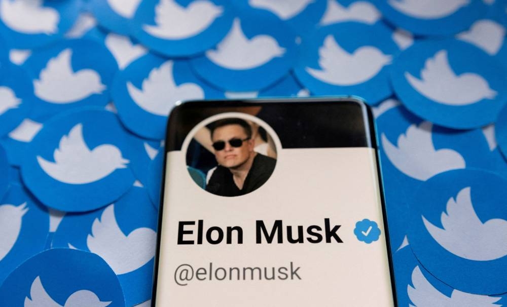 Elon Musk's Twitter profile is seen on a smartphone placed on printed Twitter logos in this picture illustration taken April 28, 2022. — Reuters pic