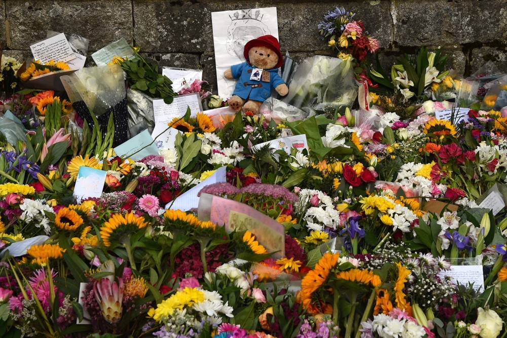 A Paddington teddy bear sits amongst flowers outside the Balmoral Castle in Ballater, on September 11, 2022 before Queen Elizabeth II's coffin travels to Edinburgh. — AFP pic