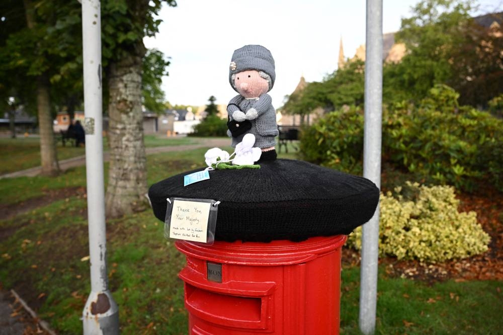A knitted Queen Elizabeth II with a thank you note is pictured above a post box in the Scottish village of Ballater on September 11, 2022. — AFP pic