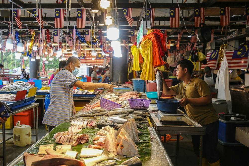 A fishmonger prepares an order of fresh fish in the Seksyen 6 wet market in Shah Alam on September 8, 2022. — Picture by Yusof Mat Isa