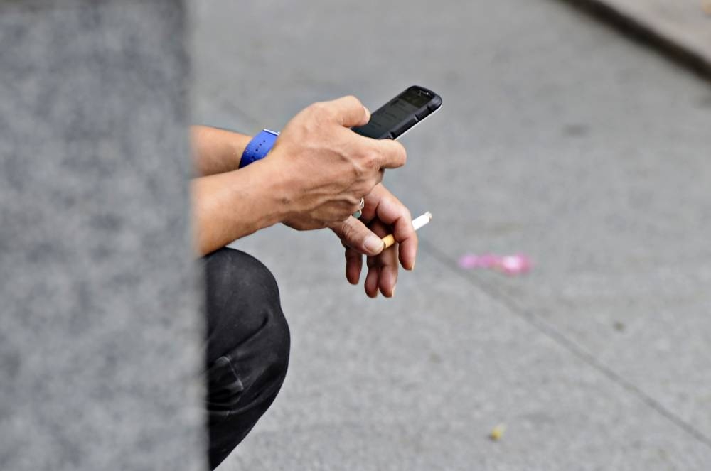 A man smokes a cigarette on the sidewalk in Kuala Lumpur August 3, 2022. ― Picture by Shafwan Zaidon