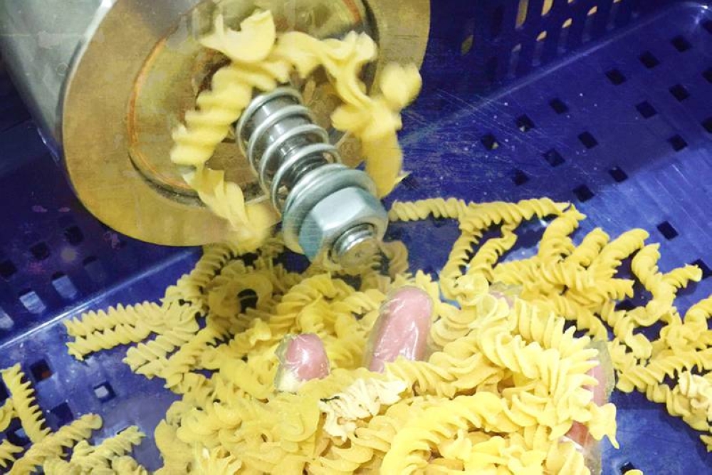 Pasta machine extruding spiral-shaped 'nuudles.'