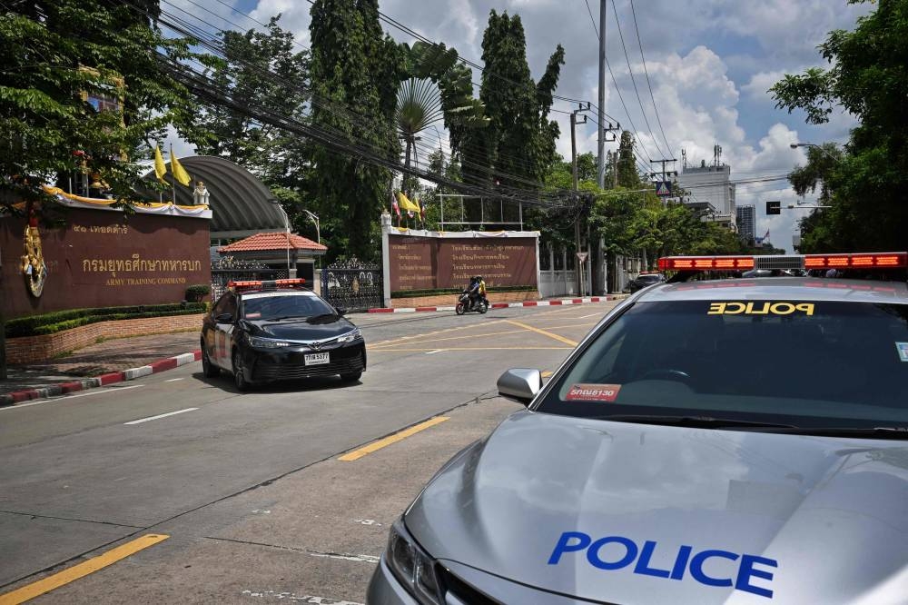This picture shows police cars parked outside the gates after an alleged shooter was detained in the Army Training Command in Bangkok on September 14, 2022. ― AFP pic