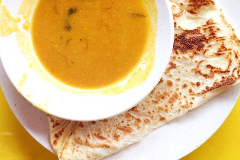 Crispy 'roti canai' with a saucer of mildly spiced dhal. — Pictures by CK Lim