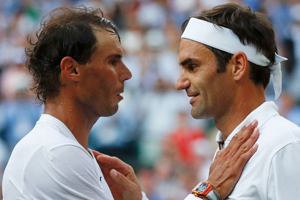 In this file photo taken on July 12, 2019 Switzerland's Roger Federer (right) shakes hands and embraces Spain's Rafael Nadal (left) after Federer won their men's singles semi-final match on day 11 of the 2019 Wimbledon Championships at The All England Lawn Tennis Club in Wimbledon, southwest London. — Adrian Dennis/Pool/AFP pic