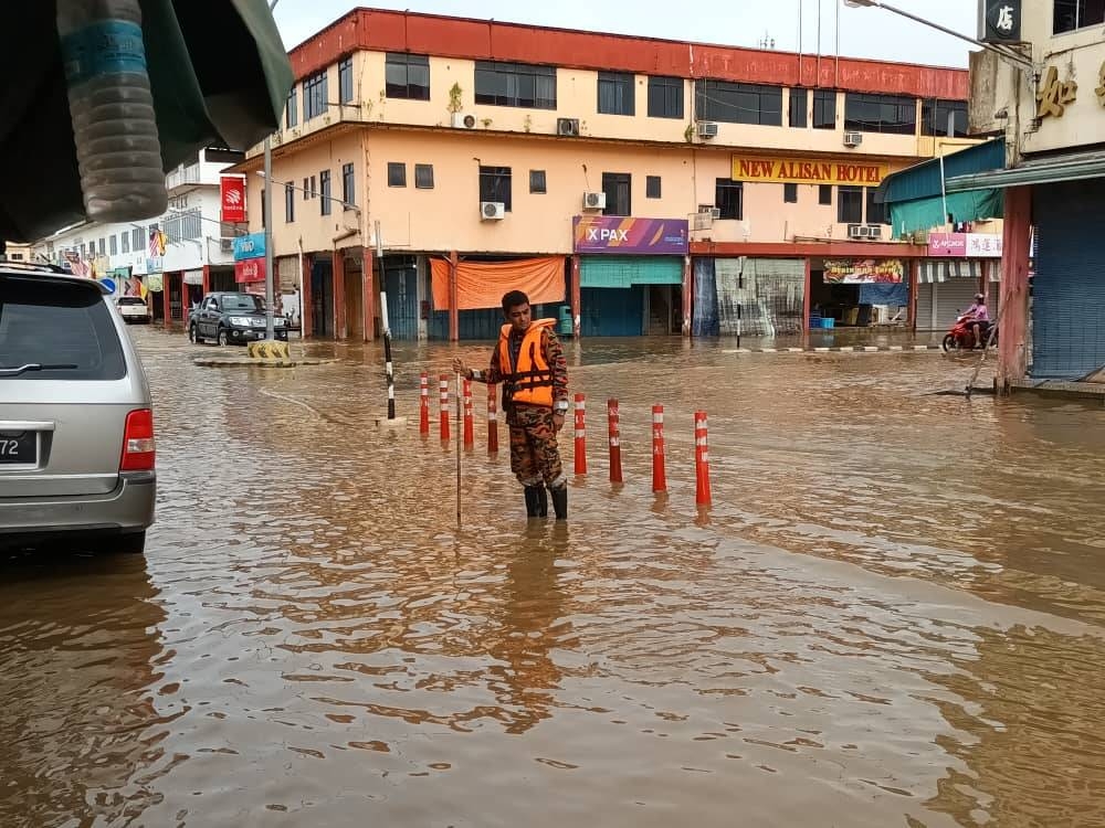 A firefighters monitors flooding in Marudi town on Thursday. — Borneo Post Online pic