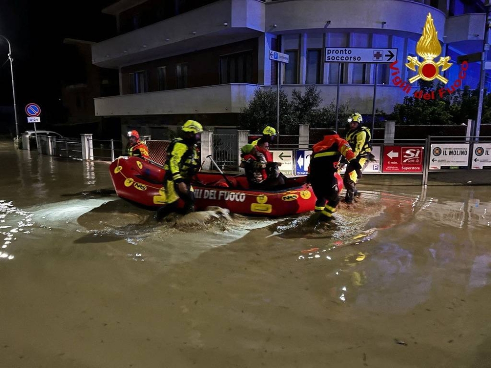 Rescue workers rescue people on a dinghy boat on a flooded street after heavy rains hit the east coast of Marche region in Senigallia, Italy, September 16, 2022. — Vigili del Fuoco handout pic via Reuters