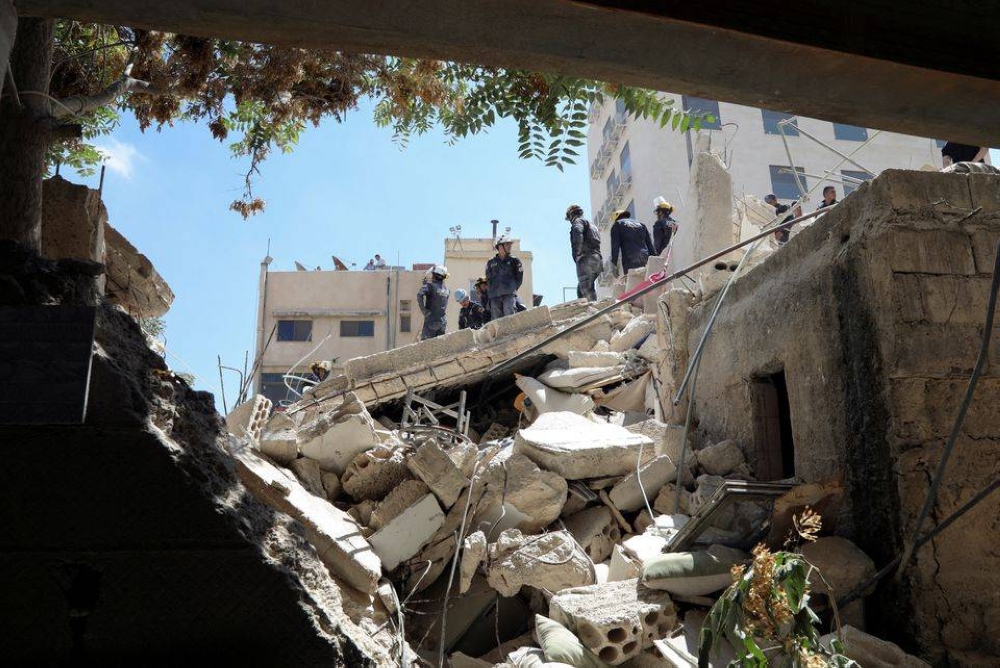 Rescuers search for survivors under the rubble of a collapsed building in Amman, Jordan, September 14, 2022. — Reuters pic