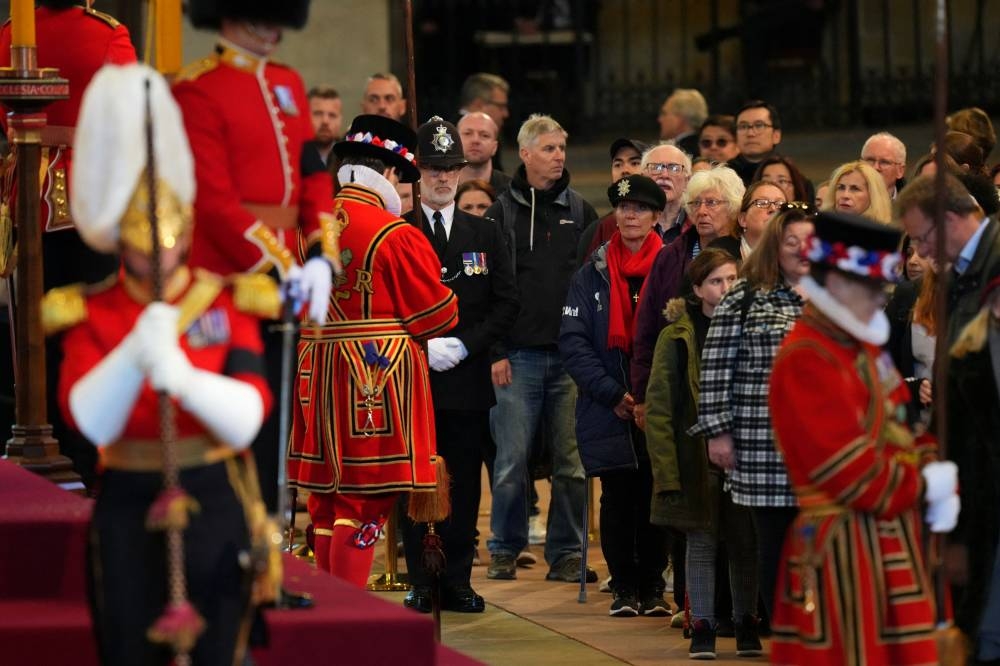 Members of the public file past the coffin of Queen Elizabeth II, draped in the Royal Standard with the Imperial State Crown and the Sovereign’s orb and sceptre, lying in state on the catafalque in Westminster Hall, at the Palace of Westminster on September 17, 2022 in London, England. — Reuters pic