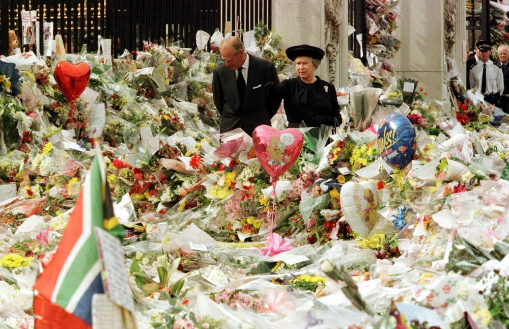 File photo of Queen Elizabeth II  and Duke of Edinburgh looking at the mass of floral tributes laid outside Buckingham Palace in memory of  Diana, Princess of Wales, September 5. — Reuters pic