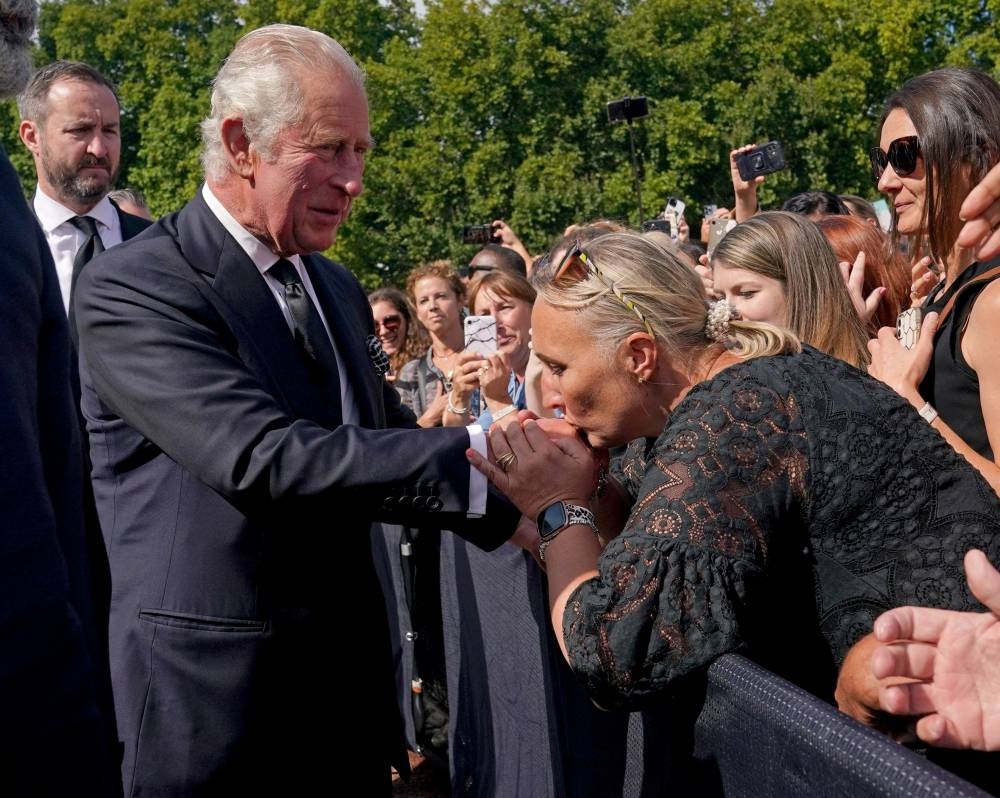 A well-wisher kisses the hand of King Charles III  during a walkabout outside Buckingham Palace, London, to view messages and tributes following the death of Queen Elizabeth II on Thursday. Picture date: Friday September 9, 2022. — Reuters pic