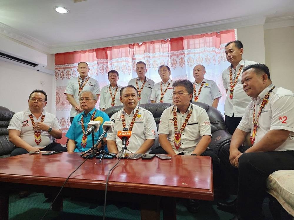 Henry (seated centre) speaks to the press. Lidang is seated right while Giendam is seated left. — Borneo Post Online pic