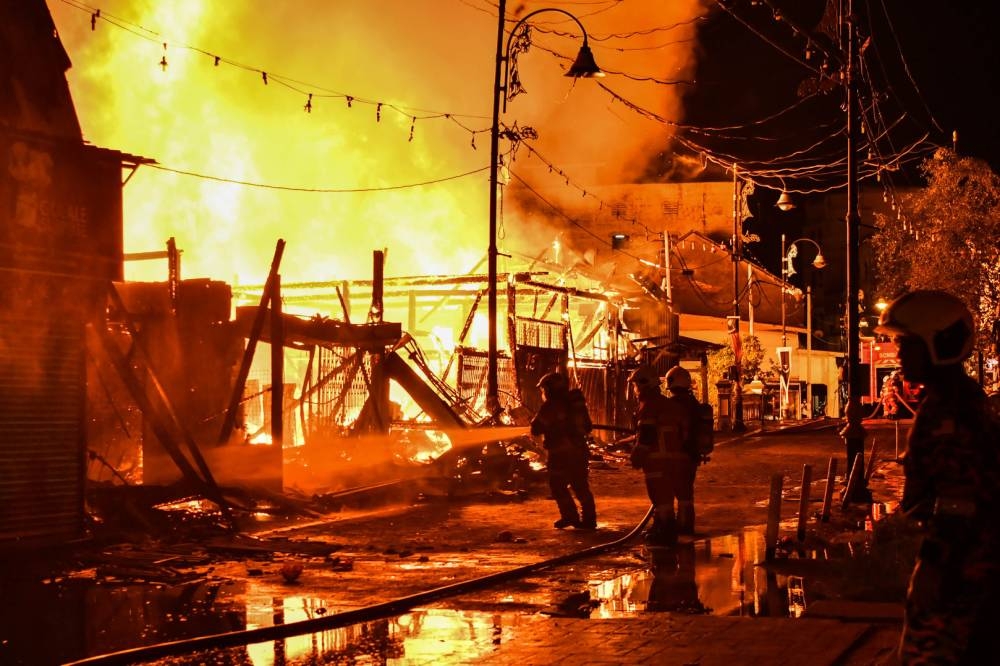 Firemen from the Terengganu Malaysian Fire and Rescue Department work to put out the fire at Jalan Kampung Cina in Kuala Terengganu September 18, 2022. — Bernama pic