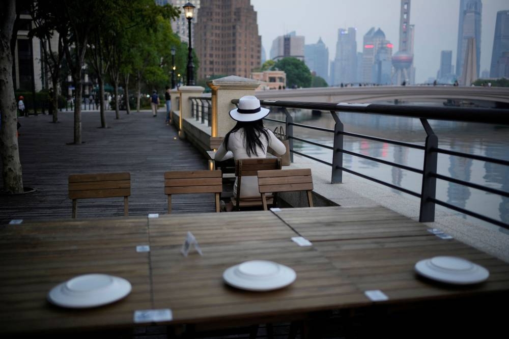 A woman sits in a restaurant on a river bank, following the coronavirus disease outbreak, in Shanghai, China, September 6, 2022. — Reuters pic