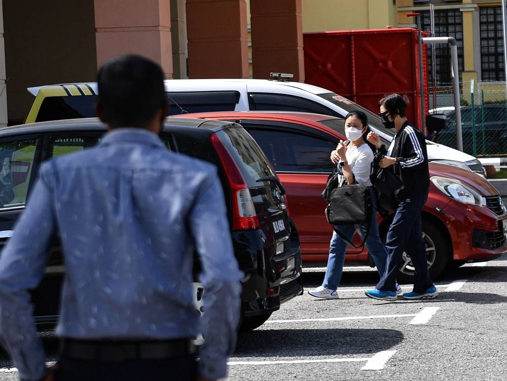 Pilot Tsz Kin Richard Chan's wife, Leung (second right), arrives at the Raja Permaisuri Bainun Hospital Forensic Department to collect his remains, in Ipoh September 19, 2022. — Bernama pic